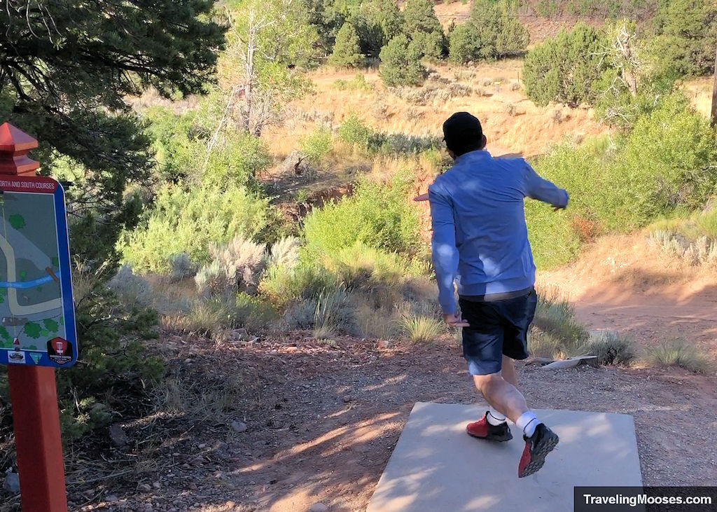 Man teeing off at a disc golf course