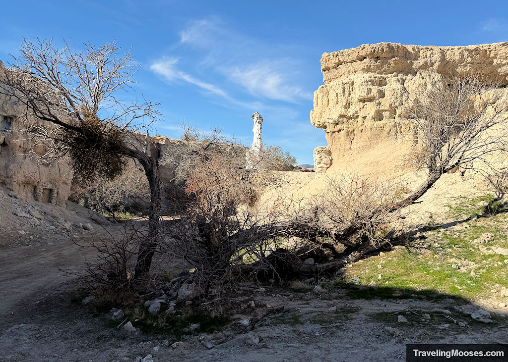 Canyon area with a white decaying Christ statue rising from the ground