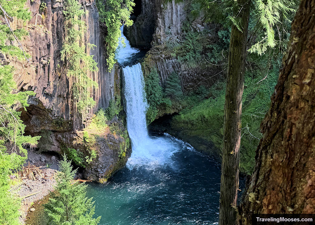 Thick waterfall falling into an aqua pool