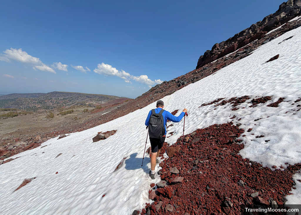 Hiker crossing the snow scree covered fields of the Broken Hand Traverse