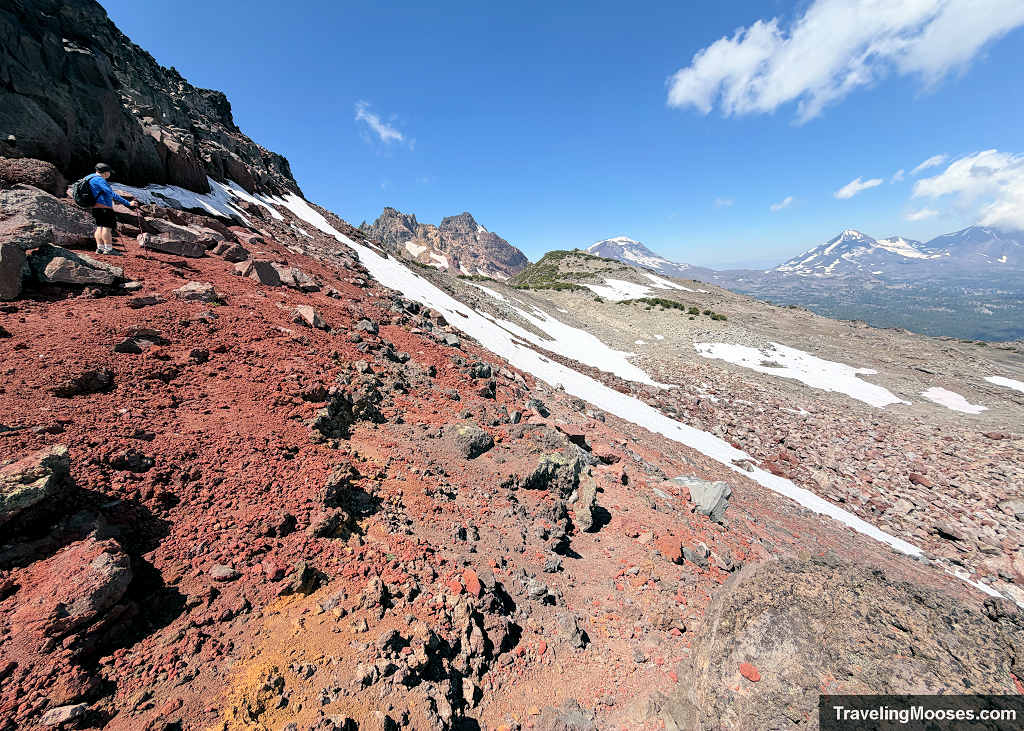 Steep boulder-choked scramble through loose red volcanic rock near the base of Broken Hand