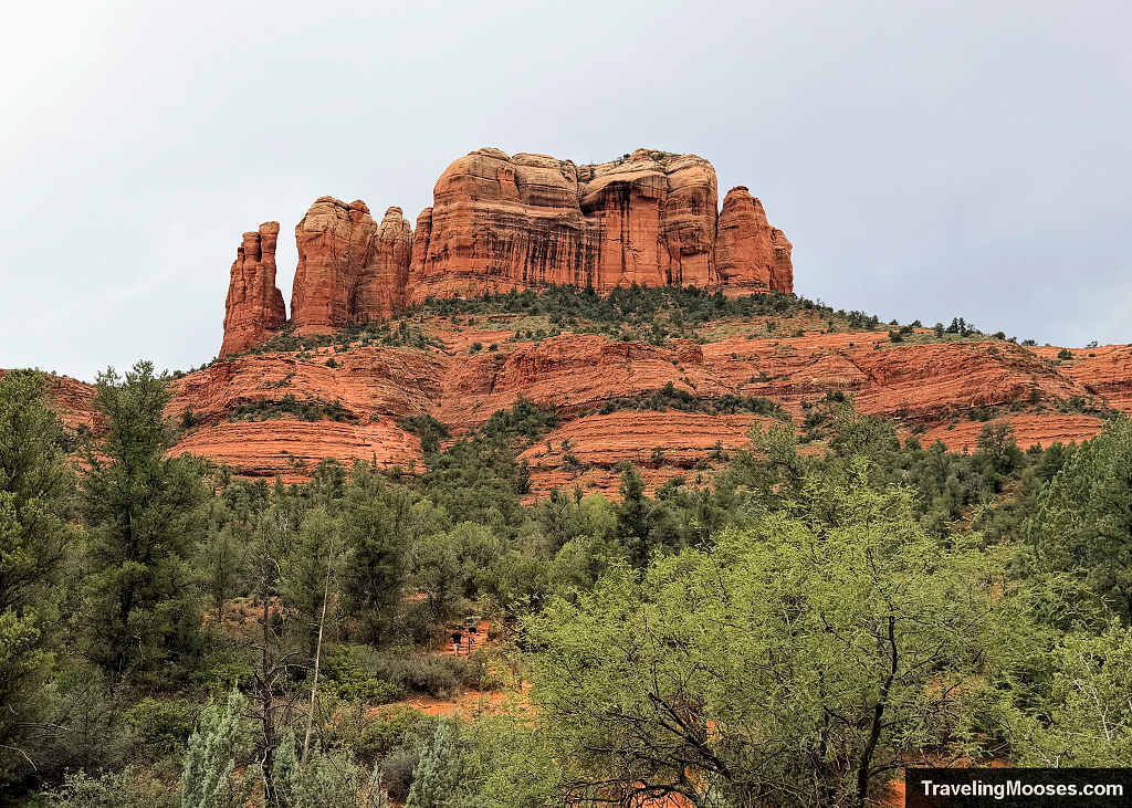 Cathedral Rock towering over green juniper and red dirt trails near Village of Oak Creek Sedona