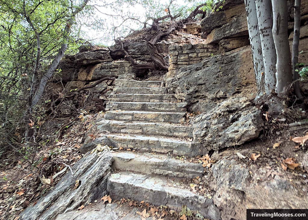 teep, narrow stone staircase without handrails descending through limestone rocks and tree roots toward the irrigation ditch at Montezuma Well.