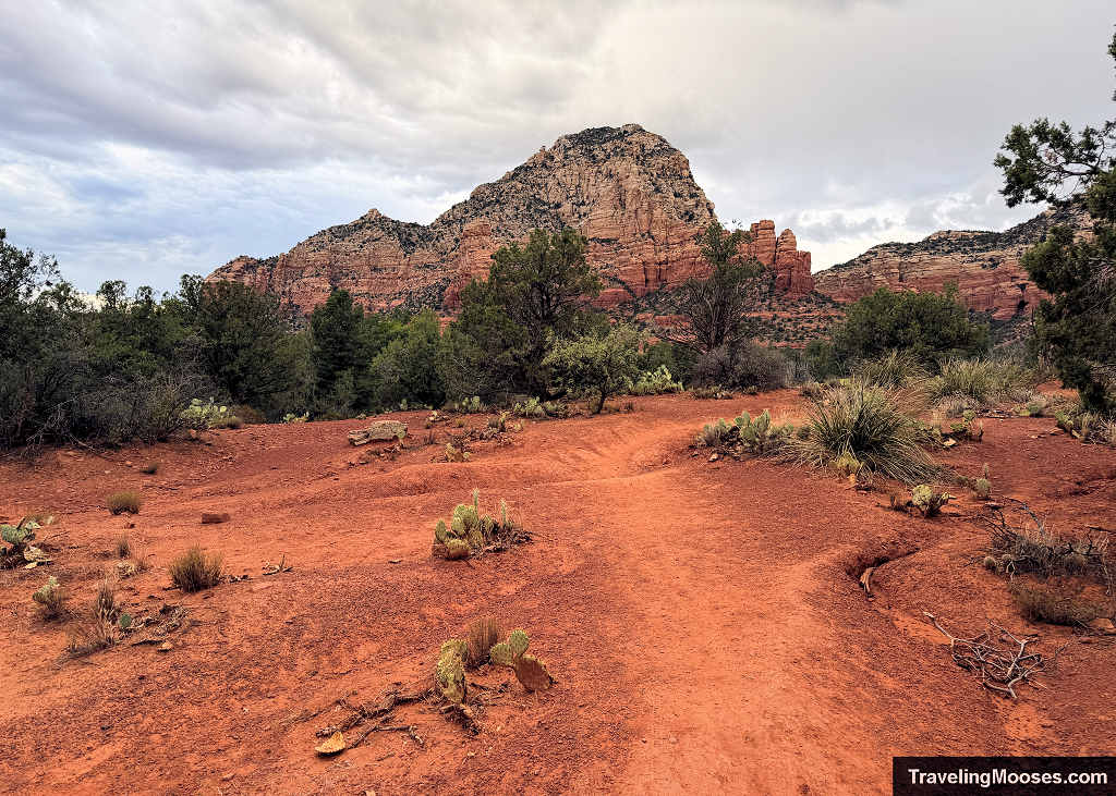 Red dirt path at the Sugarloaf Trailhead looking toward Capitol Butte and Thunder Mountain under an overcast sky in Sedona.