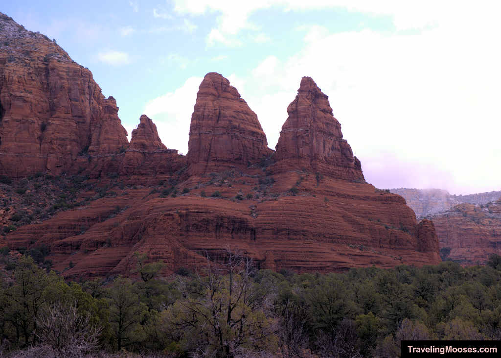 Prominent view of the Two Nuns sandstone spires rising above red rock ledges