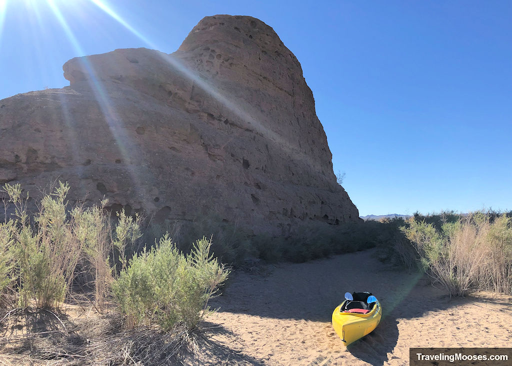 kayak on a sandy path near large rock formation