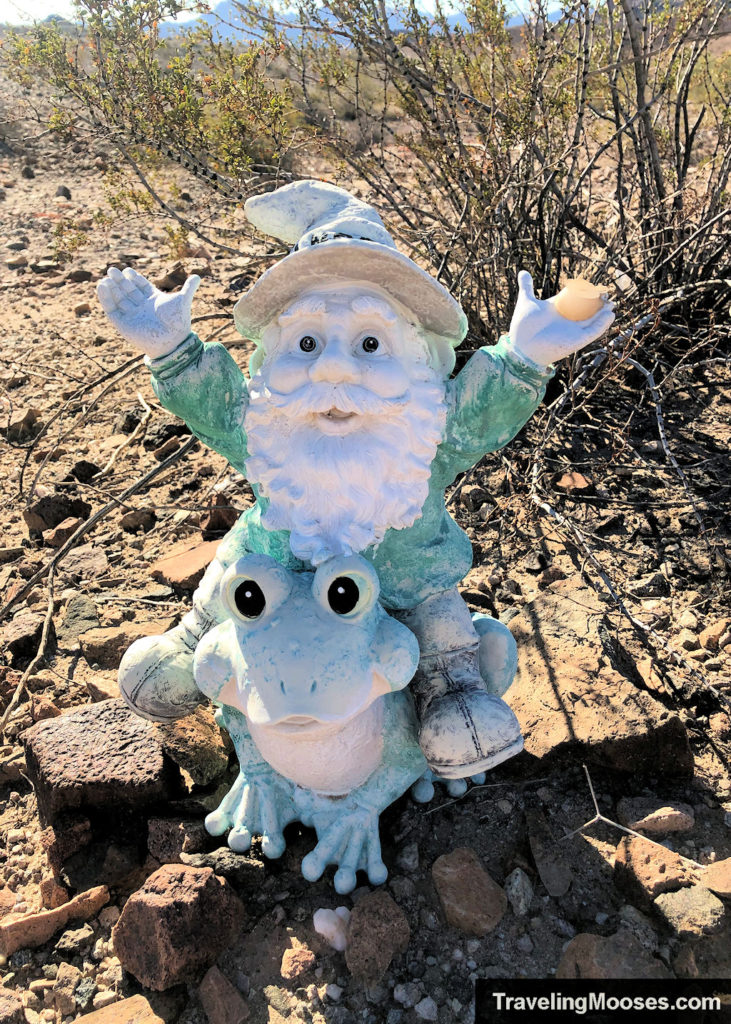 brightly colored nome statue whom is riding a green frog