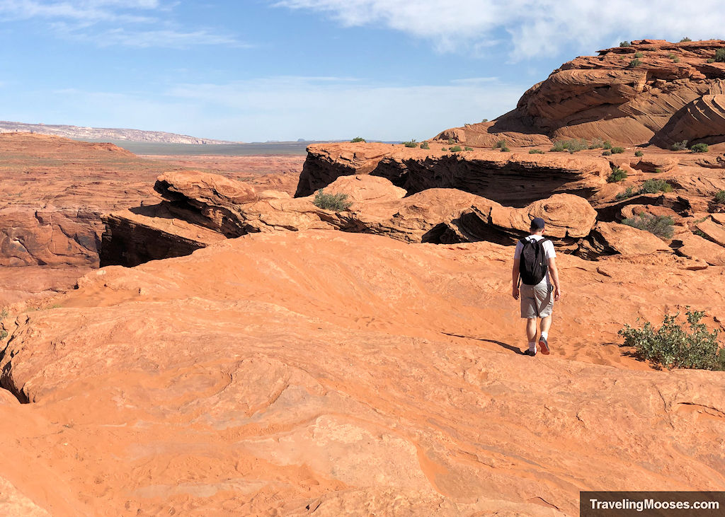 Man walking along the sandstone rocks at Horseshoe Bend