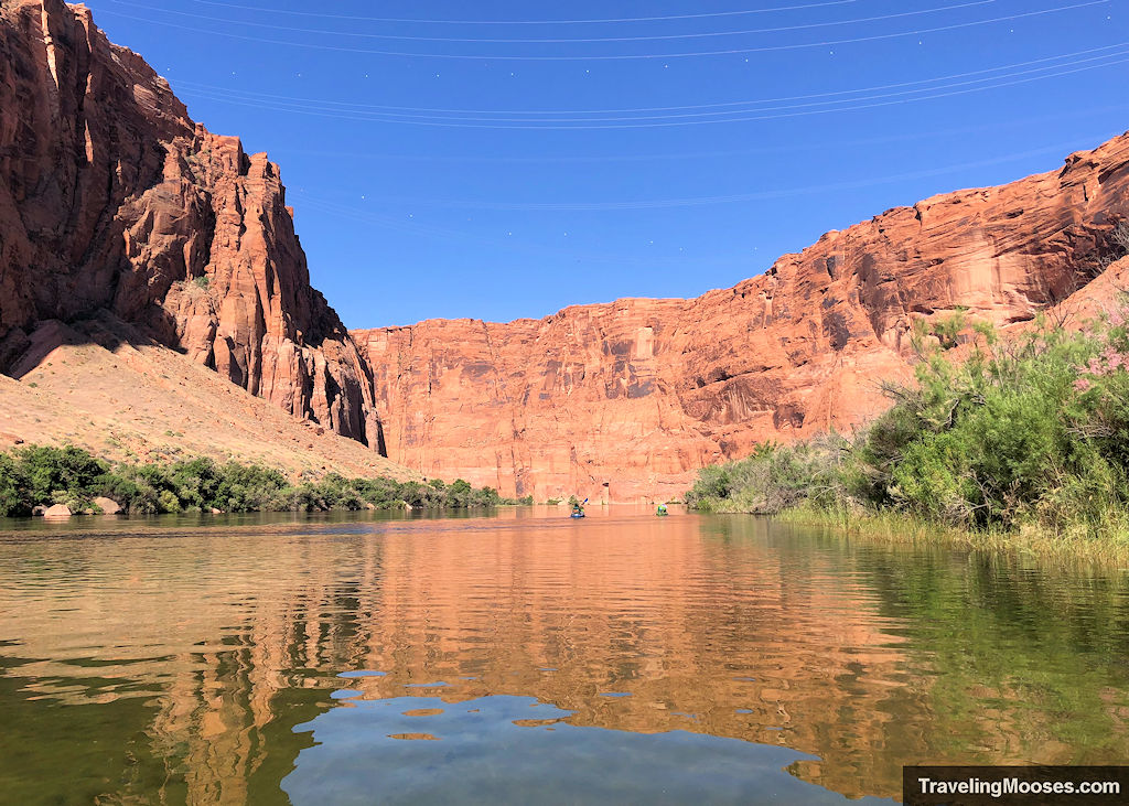Kayakers paddling down the crystal waters of the Colorado River in Glen Canyon
