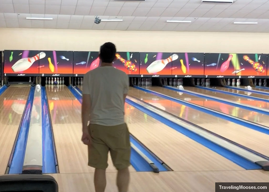 Man bowling a strike at bowling alley