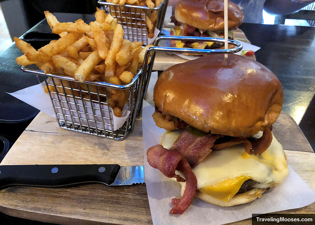 Bacon Cheeseburger and french fries in a wire basket