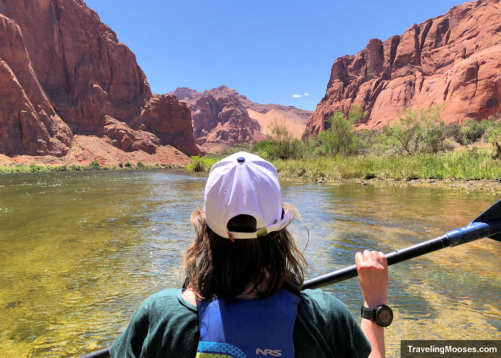 Woman paddling down the Colorado River surrounded by 1,000 foot canyon walls