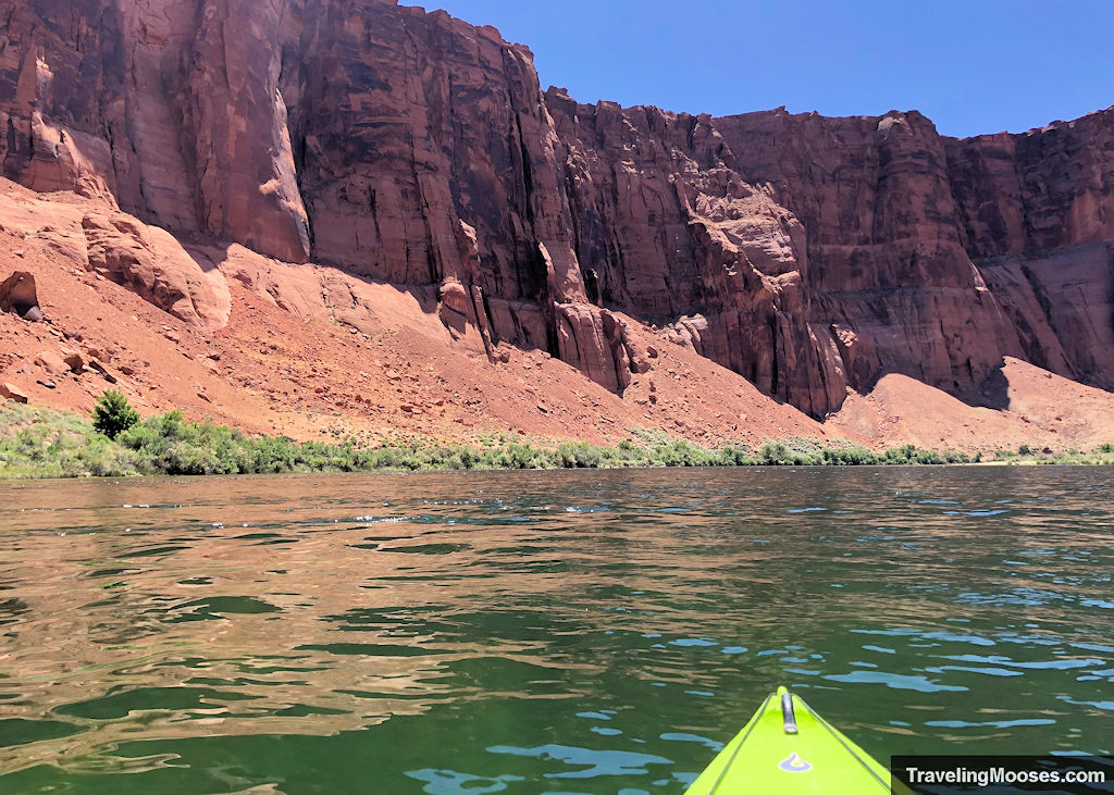 Kayak tip seen on the water with large canyon walls in the distance