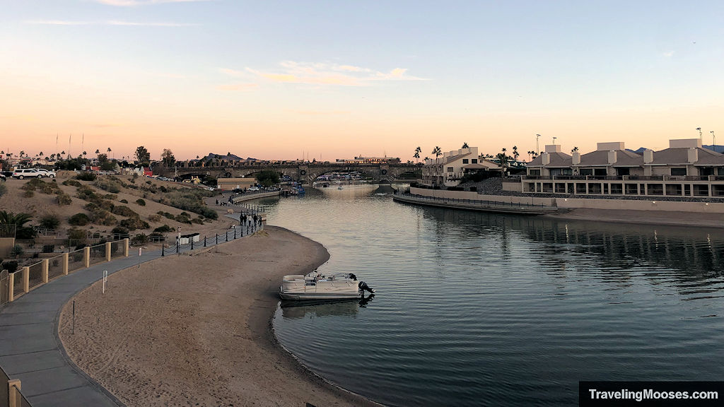 Waterfront Channel with a vessel tied to the shore and the London Bridge seen in the distance