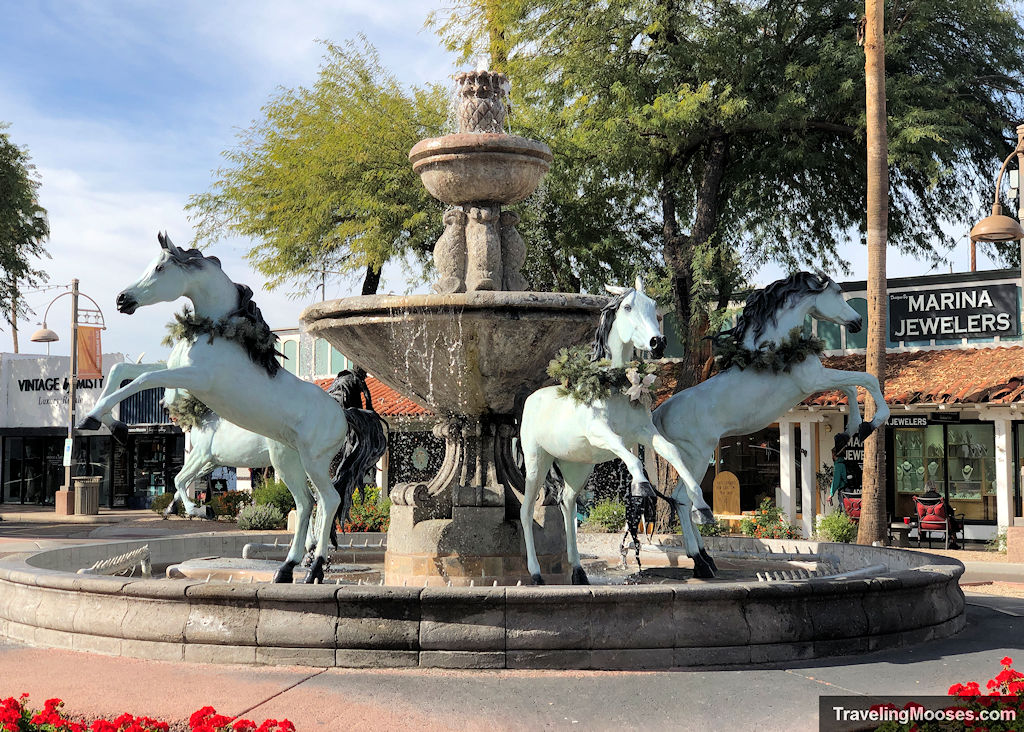 Bronze horse statutes painted white leaping from a fountain