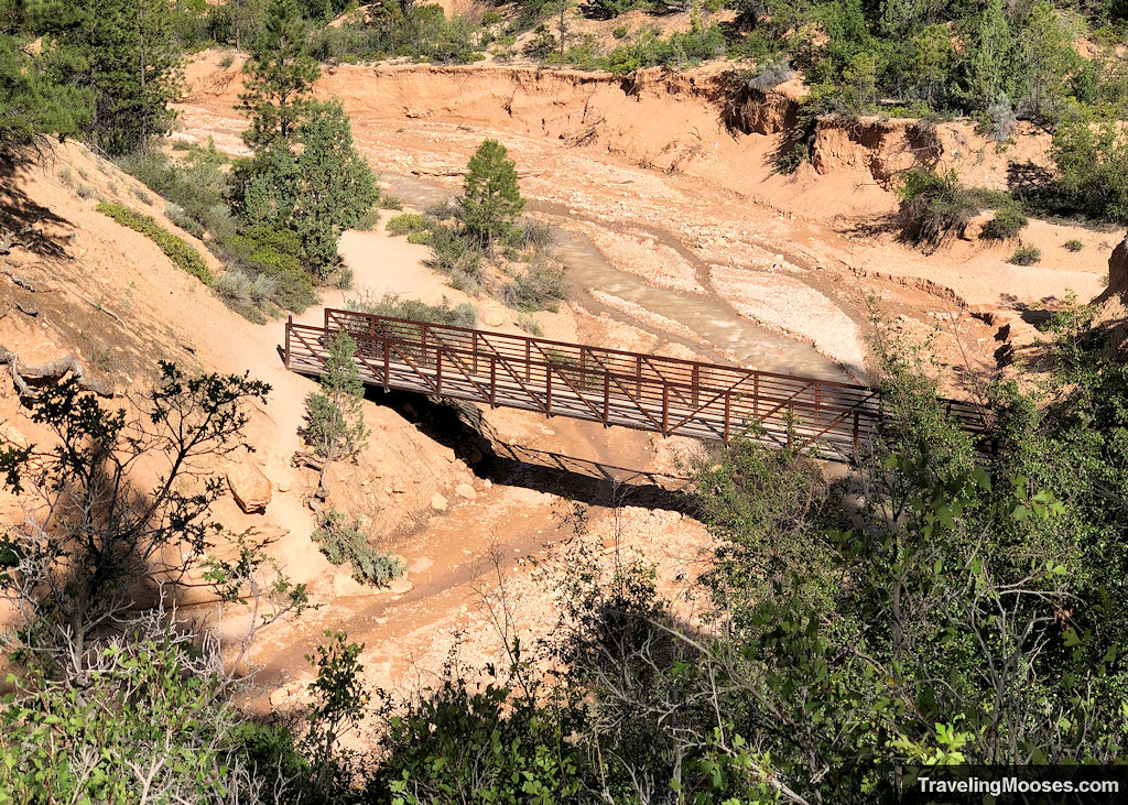 Steel foot path bridge crossing over the Tropic Ditch filled with a low amount of water