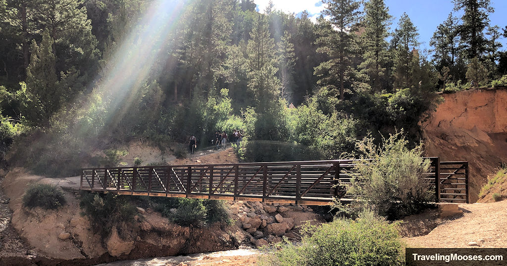 Brown steel bridge over stream crossing