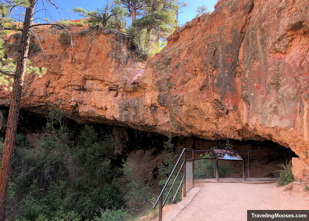 Cave carved into the ancient rock with a pedestrian overlook