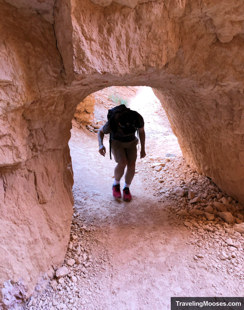 Man walking under stone archway