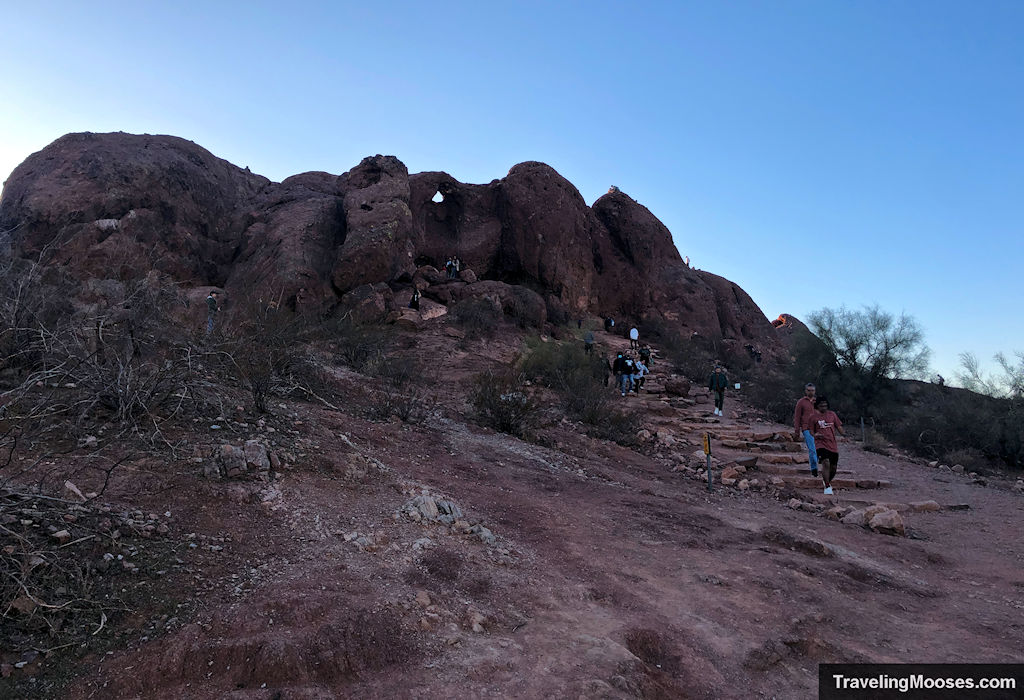 Hikers walk towards the final trail steps to the Hole in the Rock