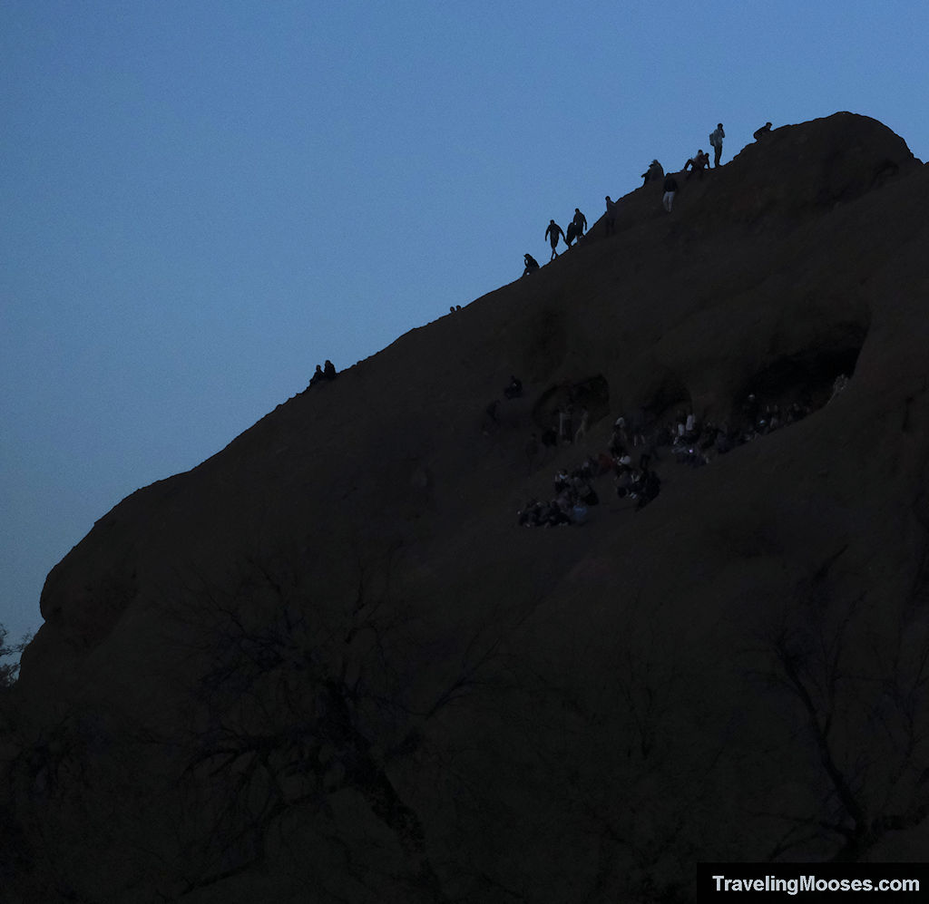 Visitors climbing a sandstone rock formation at Papago Park