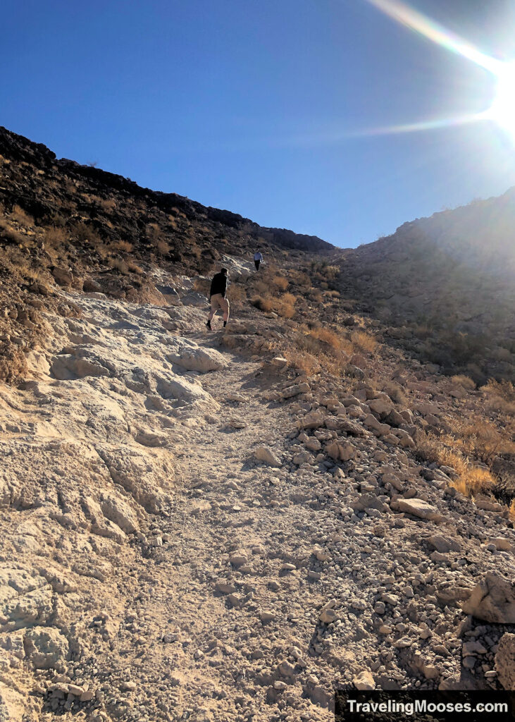 Man walking up a steep gravel slope