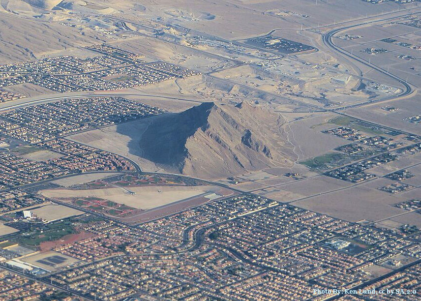 A large mountain peak seen by itself arising from the desert floor