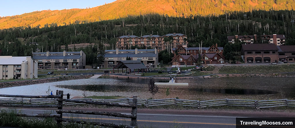 Evening view of Bristlecone Pond in Brian Head, Utah, with resorts and mountain slopes in the background.