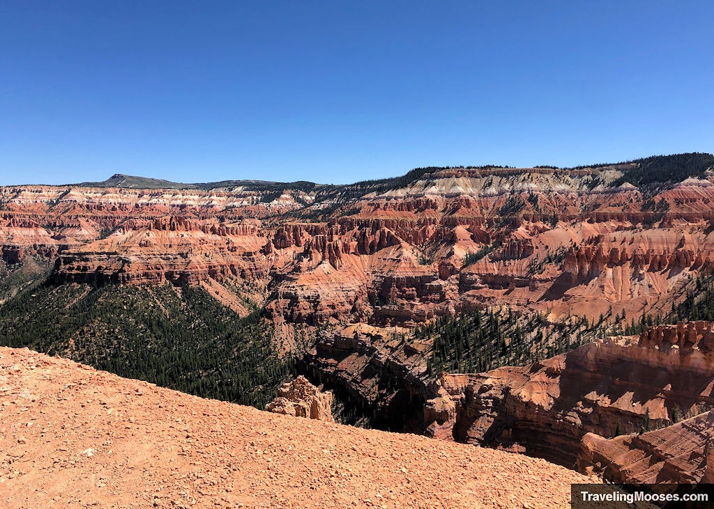 A mountain side filled with red and white hoodoos