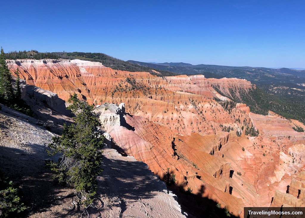 View of the Cedar Breaks amphitheater with layered red cliffs and ridgelines, seen from the Sunset View Overlook.